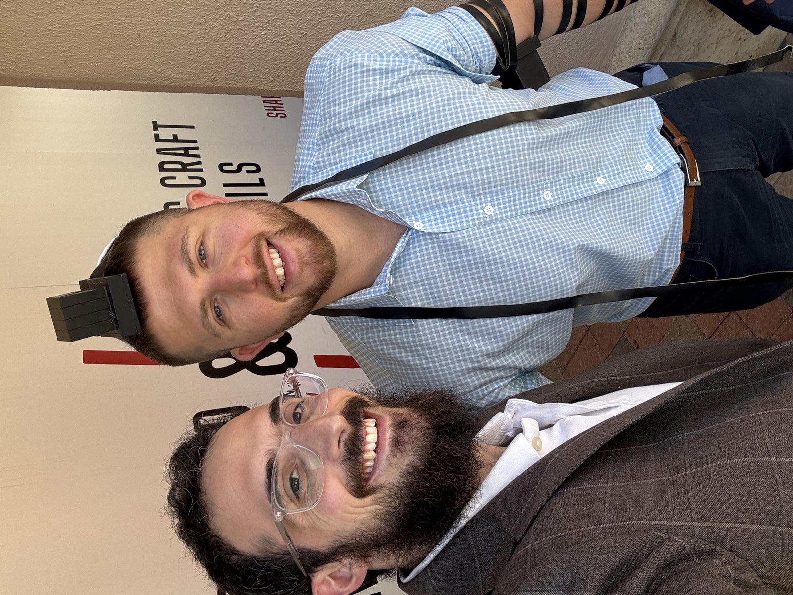 Rabbi Yosef with a community member wearing tefillin, smiling together